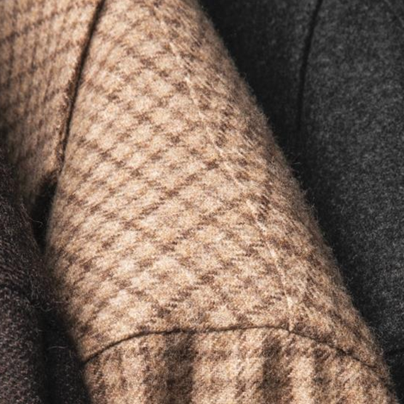 Primo piano della spalla di una giacca beige a quadri